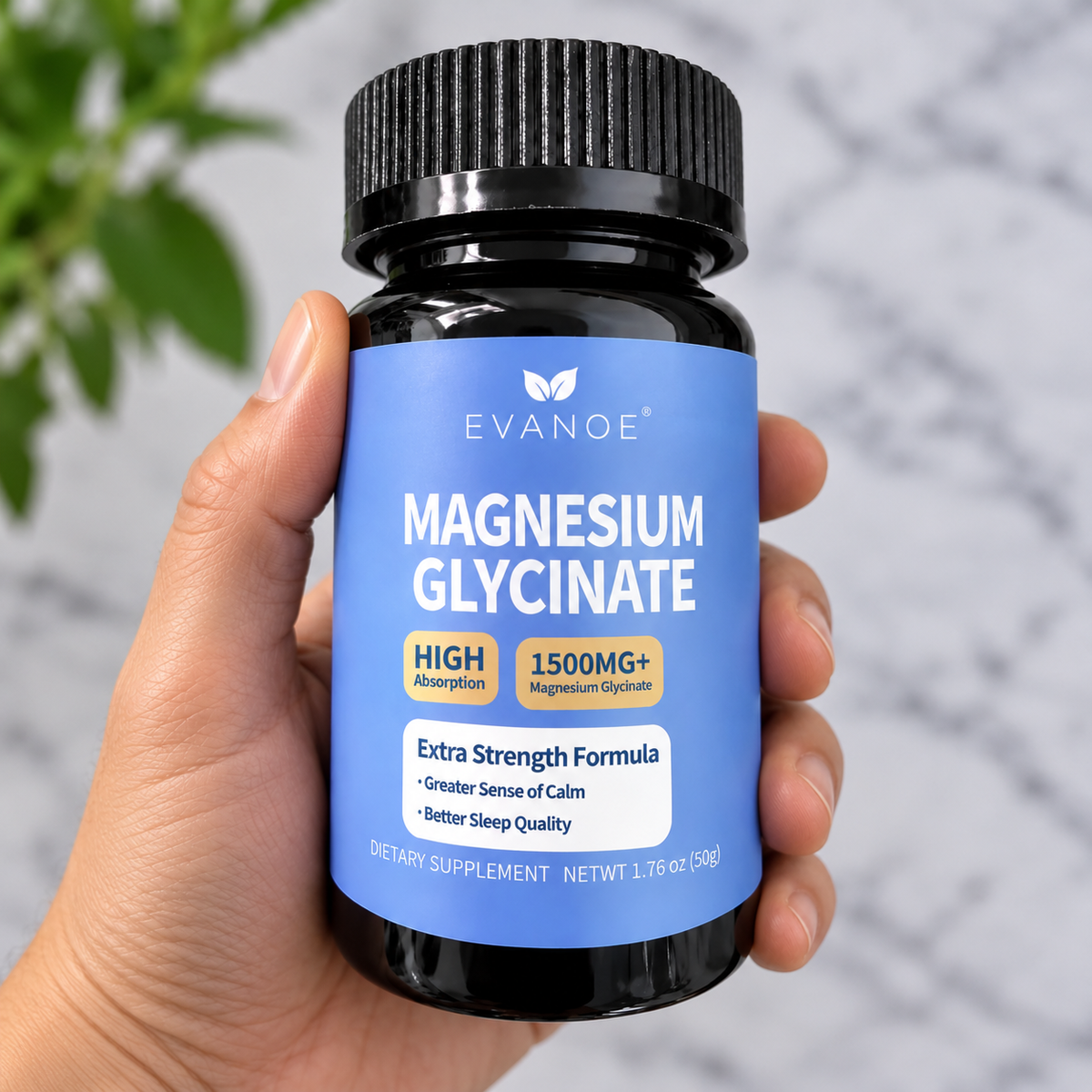 A hand holding a black bottle of EVANOE Magnesium Glycinate dietary supplement against a soft marble background with a hint of green foliage.